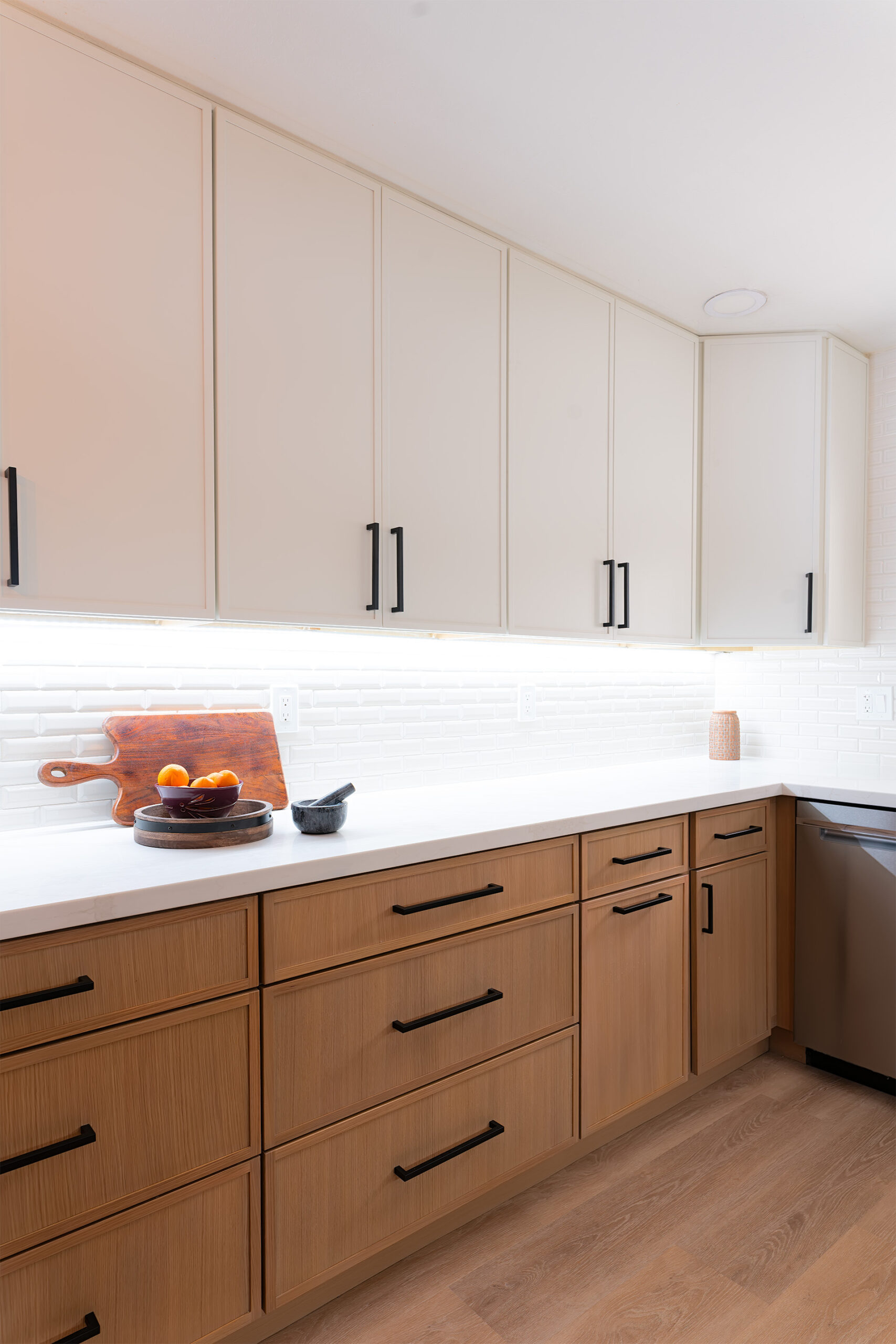 Remodeled kitchen with warm wood cabinetry and stone backsplash